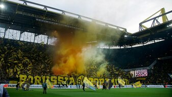Fans von Dortmund brennen vor einem Spiel Rauch-Pyrotechnik ab.