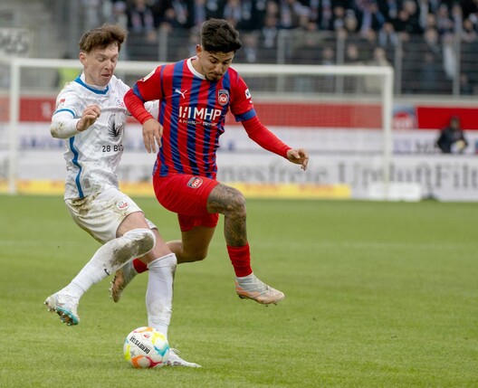 Der Heidenheimer Kevin Sessa (r) geht in den Zweikampf mit Haris Duljevic von Hansa Rostock.