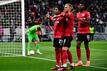 Leverkusens Torschütze Amine Adli (l-r) jubelt nach seinem Tor zum 0:2 mit Mitchel Bakker und Edmond Tapsoba.