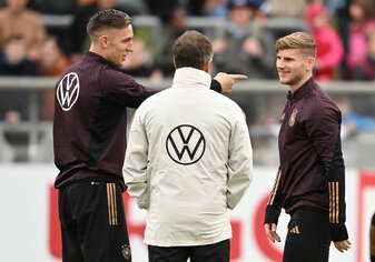 Timo Werner (r), Nico Schlotterbeck (l) und Bundestrainer Hansi Flick sprechen während einer Trainigseinheit miteinander. Timo Werner (r), Nico Schlotterbeck (l) und Bundestrainer Hansi Flick sprechen während einer Trainigseinheit miteinander.