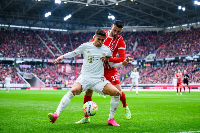 Münchens João Cancelo (l) in Aktion gegen Freiburgs Vincenzo Grifo (r).