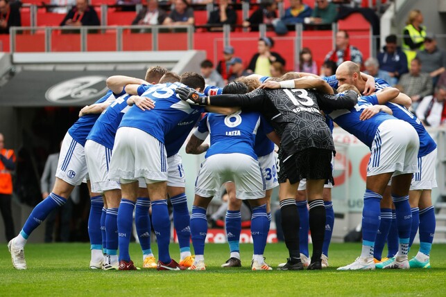 Die Spieler des FC Schalke 04 stehen vor Spielbeginn gemeinsam auf dem Platz im Kreis.