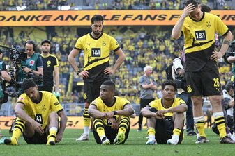 Spieler von Borussia Dortmund sitzen nach dem Spiel enttäuscht auf dem Platz. Spieler von Borussia Dortmund sitzen nach dem Spiel enttäuscht auf dem Platz.
