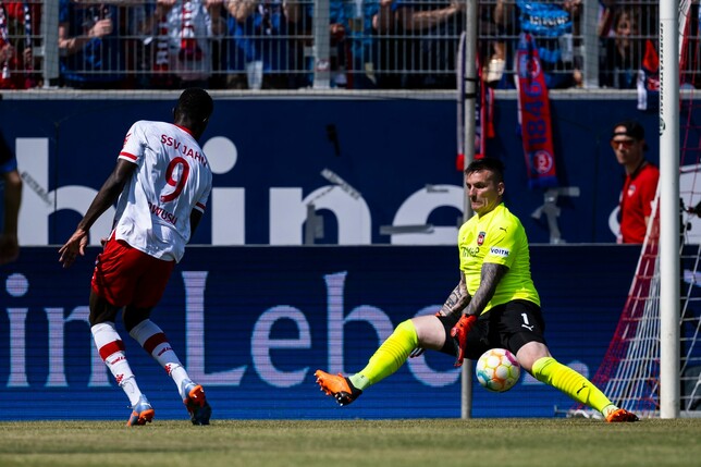 Regensburgs Prince Owusu (l) in Aktion gegen Heidenheims Torwart Kevin Müller.
