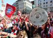 Bayern-Fans jubeln auf dem Marienplatz mit Fahnen, Schals und Meisterschalen.