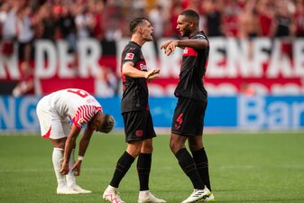 Leverkusens Granit Xhaka (M) und Jonathan Tah klatschen sich nach der Partie ab. Links Leipzigs Benjamin Henrichs. Leverkusens Granit Xhaka (M) und Jonathan Tah klatschen sich nach der Partie ab. Links Leipzigs Benjamin Henrichs.