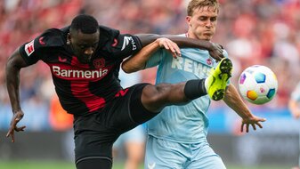 Kölns Timo Hübers (r) und Leverkusens Victor Boniface kämpfen um den Ball. Kölns Timo Hübers (r) und Leverkusens Victor Boniface kämpfen um den Ball.