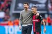 Leverkusens Trainer Xabi Alonso (l) und Alejandro Grimaldo liegen sich nach der Partie in den Armen.