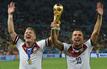 Bastian Schweinsteiger (l) und Lukas Podolski jubeln nach dem Sieg der FIFA-Weltmeisterschaft 2014 mit dem Pokal.