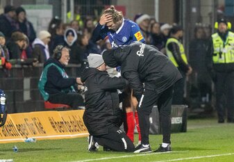 Kiels Fiete Arp wird während der Partie gegen Hannover 96 am Spielfeldrand behandelt. Kiels Fiete Arp wird während der Partie gegen Hannover 96 am Spielfeldrand behandelt.
