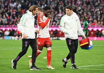 Alphonso Davies (M) wird verletzt vom Platz begleitet. Alphonso Davies (M) wird verletzt vom Platz begleitet.