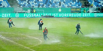 Arbeiter versuchten, Wasserlachen vom Spielfeld im Ludwigsparkstadion zu entfernen. Arbeiter versuchten, Wasserlachen vom Spielfeld im Ludwigsparkstadion zu entfernen.