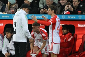 Bayerns Thomas Müller (r) spricht bei seiner Einwechslung mit Trainer Thomas Tuchel.