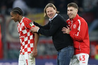 Trainer Bo Henriksen von Mainz und seine Spieler Leandro Barreiro (l) und Brajan Gruda freuen sich nach dem Schlusspfiff über den Sieg. Trainer Bo Henriksen von Mainz und seine Spieler Leandro Barreiro (l) und Brajan Gruda freuen sich nach dem Schlusspfiff über den Sieg.