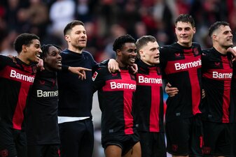 Leverkusens Trainer Xabi Alonso (3.v.l.) feiert nach der Partie mit den Spielern vor der Kurve. Leverkusens Trainer Xabi Alonso (3.v.l.) feiert nach der Partie mit den Spielern vor der Kurve.