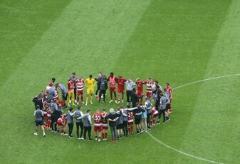 Der Düsseldorfer Trainer Daniel Thioune (M) spricht auf dem Spielfeld mit seinen Spielern. Der Düsseldorfer Trainer Daniel Thioune (M) spricht auf dem Spielfeld mit seinen Spielern.