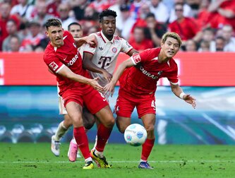 Bayerns Kingsley Coman (M) im Kampf mit zwei Freiburger Gegenspielern. Bayerns Kingsley Coman (M) im Kampf mit zwei Freiburger Gegenspielern.