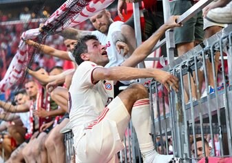Thomas Müller steigt nach dem Bayern-Sieg auf den Zaun zu den Fans. Thomas Müller steigt nach dem Bayern-Sieg auf den Zaun zu den Fans.