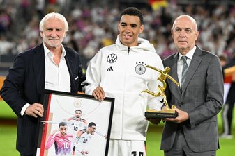 Rudi Völler (l) hört 2026 als DFB-Sportdirektor aus. Beim Ungarn-Spiel zeichnet er gemeinsam mit DFB-Präsident Bernd Neuendorf (r) Nationalspieler Jamal Musiala nach seinen drei EM-Toren aus. Rudi Völler (l) hört 2026 als DFB-Sportdirektor aus. Beim Ungarn-Spiel zeichnet er gemeinsam mit DFB-Präsident Bernd Neuendorf (r) Nationalspieler Jamal Musiala nach seinen drei EM-Toren aus.