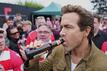Schauspieler Ryan Reynolds lässt sich vor dem Spiel seines Clubs AFC Wrexham ein Bier schmecken.