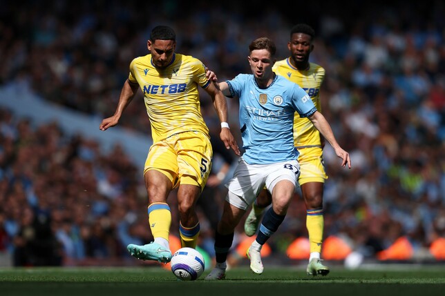 MANCHESTER, ENGLAND - APRIL 12: Maxence Lacroix of Crystal Palace passes the ball under pressure from James McAtee of Manchester City during the Premier League match between Manchester City FC and Cry