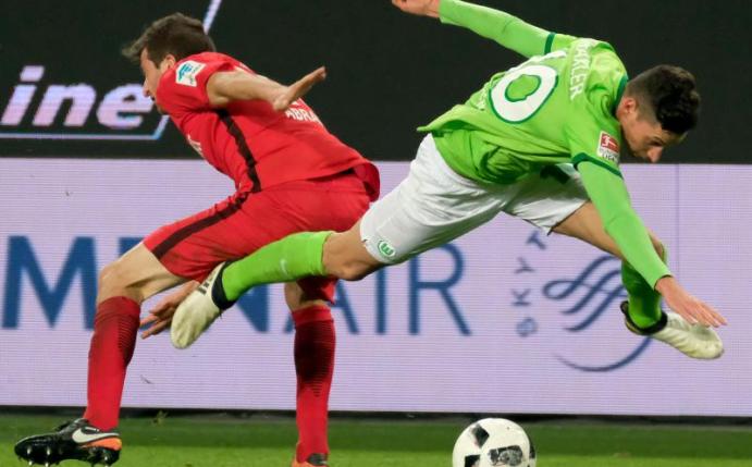 Wolfsburgs Julian Draxler (r) und Frankfurts David Abraham kämpfen um den Ball. Foto: Peter Steffen
