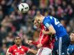 Münchens Robert Lewandowski (l) im Luftduell mit Schalkes Holger Badstuber. Foto: Matthias Balk