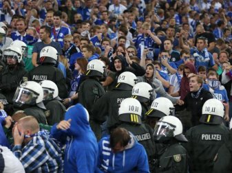 Polizisten stehen im August 2013 in der Veltins-Arena in Gelsenkirchen beim Champions-League-Playoffspiel zwischen dem FC Schalke 04 und PAOK Saloniki zwischen den Fans. Foto: Friso Gensch Polizisten stehen im August 2013 in der Veltins-Arena in Gelsenkirchen beim Champions-League-Playoffspiel zwischen dem FC Schalke 04 und PAOK Saloniki zwischen den Fans. Foto: Friso Gensch