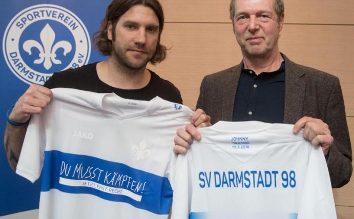 Trainer Torsten Frings (l) präsentiert ein Sondertrikot zum ersten Todestag von Jonathan Heimes zusammen mit dessen Vater Martin. Foto: Frank Rumpenhorst