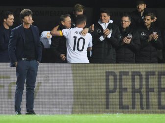 Während Bundestrainer Löw (l) schon an das kommende Spiel in Baku zu denken scheint, verabschiedet sich Lukas Podolski (10) vom Team. Foto: Bernd Thissen Während Bundestrainer Löw (l) schon an das kommende Spiel in Baku zu denken scheint, verabschiedet sich Lukas Podolski (10) vom Team. Foto: Bernd Thissen