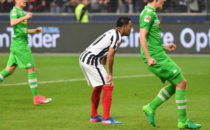 Frankfurts Marco Fabian (M) steht nach seinem vergebenen Elfmeter inmitten der jubelnden Mönchengladbacher. Foto: Arne Dedert