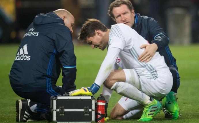 HSV-Torwart Rene Adler muss nach dem Zusammenprall mit Pierre-Emerick Aubameyang behandelt werden. Foto: Bernd Thissen