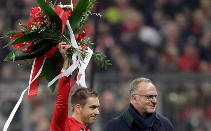 Bayern-Kapitän Philipp Lahm (l) erhält von Vorstandschef Karl-Heinz Rummenigge einen Blumenstrauß für sein 500. Pflichtspiel für den FC Bayern. Foto: Matthias Schrader