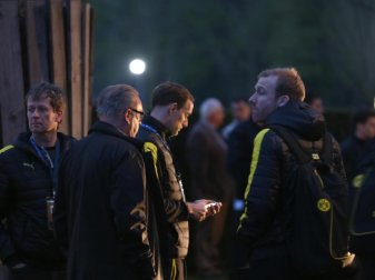 BVB-Trainer Thomas Tuchel (M) steht nach der Attacke auf den Bus mit seinem Team beisammen. Foto: Ina Fassbender BVB-Trainer Thomas Tuchel (M) steht nach der Attacke auf den Bus mit seinem Team beisammen. Foto: Ina Fassbender