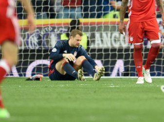 Torwart Manuel Neuer sitzt auf dem Rasen und hält sich den verletzten linken Fuß. Foto: Andreas Gebert Torwart Manuel Neuer sitzt auf dem Rasen und hält sich den verletzten linken Fuß. Foto: Andreas Gebert