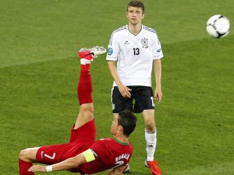 Bei der EM 2012 kommt Portugals Cristiano Ronaldo vor DFB-Spieler Thomas Müller zu einem Fallrückzieher. Foto: Sergey Dolzhenko Bei der EM 2012 kommt Portugals Cristiano Ronaldo vor DFB-Spieler Thomas Müller zu einem Fallrückzieher. Foto: Sergey Dolzhenko