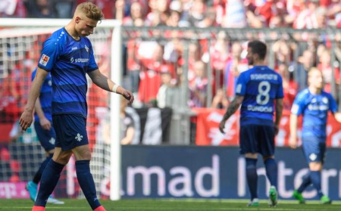 Nach dem gegen Bayern München verlorenen Spiel lassen die Darmstädter die Köpfe hängen - sie stehen als Absteiger fest. Foto: Matthias Balk