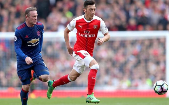Arsenals Mesut Özil (r) in Aktion gegen Wayne Rooney von Manchester United. Foto: Adam Davy/PA Wire