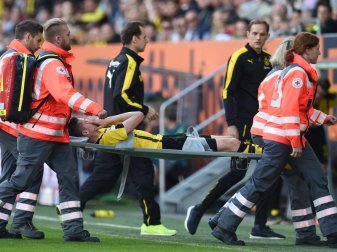 Julian Weigl wird nach seiner Fußverletzung vom Feld getragen. Im Hintergrund BVB-Trainer Thomas Tuchel (2.v.r). Foto: Andreas GebertAus Julian Weigl wird nach seiner Fußverletzung vom Feld getragen. Im Hintergrund BVB-Trainer Thomas Tuchel (2.v.r). Foto: Andreas GebertAus
