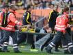 Julian Weigl wird nach seiner Fußverletzung vom Feld getragen. Im Hintergrund BVB-Trainer Thomas Tuchel (2.v.r). Foto: Andreas GebertAus