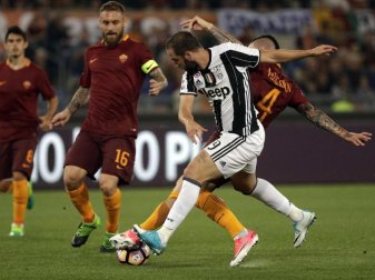 Juventus' Gonzalo Higuain (M) im Duell mit Roms Radja Nainggolan. Foto: Gregorio Borgia Juventus' Gonzalo Higuain (M) im Duell mit Roms Radja Nainggolan. Foto: Gregorio Borgia