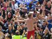 Lewis Holtby tanzt auf dem Dach der Mannschaftsbank und feiert mit den HSV-Fans den Klassenerhalt. Foto: Carmen Jaspersen