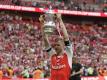 Arsenal-Spieler Per Mertesacker jubelt mit der Trophäe. Foto: Matt Dunham