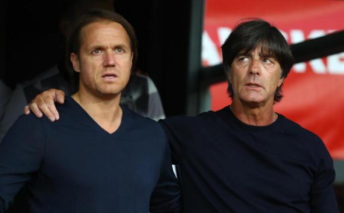 Joachim Löw (r) und Thomas Schneider singen die deutsche Nationalhymne vor dem Spiel. Foto: Christian Charisius