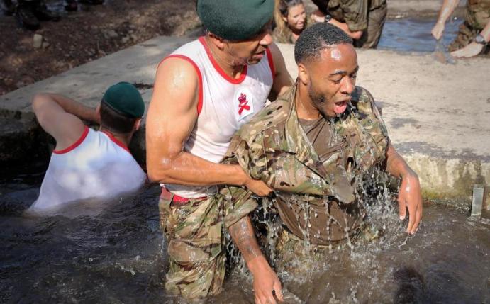 Auch Englands Stürmer Raheem Sterling wurde ordentlich durch den Schlamm gezogen. Foto: Royal Navy
