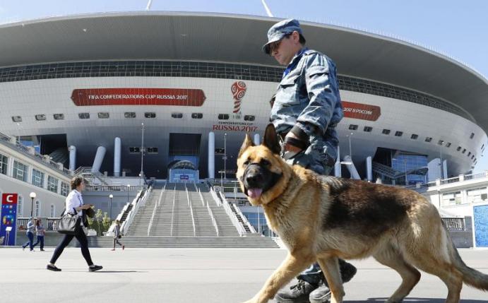 Sicherheit wird in Russland groß geschrieben: Ein Wachmann mit Hund läuft vor dem Stadion in St. Petersburg entlang. Foto: Kyodo
