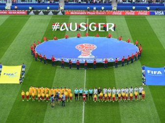 Die Mannschaften von Australien und Deutschland stehen vor dem Spiel in Sotschi auf dem Feld. Foto: Marius Becker Die Mannschaften von Australien und Deutschland stehen vor dem Spiel in Sotschi auf dem Feld. Foto: Marius Becker