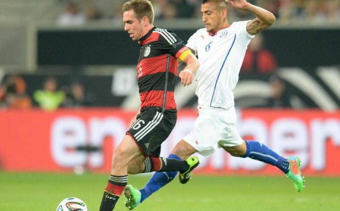 Philipp Lahm und Arturo Vidal (r) kämpfen im Länderspiel Deutschland gegen Chile am 5. März 2014 in Stuttgart um den Ball: Das letzte Aufeinandertreffen der beiden Teams endete 1:0 für die DFB-Auswahl. Foto: Bernd Weißbrod