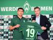 Werder Bremens Neuzugang Yuning Zhang (l) gemeinsam mit Manager Frank Baumann sein Trikot mit der Nummer 19 hoch. Foto: Carmen Jaspersen