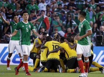 Während Jamaikas Spieler (M) über das 1:0 jubeln, zeigen die Mexikaner mit ihren Gesten Resignation. Foto: Jae Hong Während Jamaikas Spieler (M) über das 1:0 jubeln, zeigen die Mexikaner mit ihren Gesten Resignation. Foto: Jae Hong